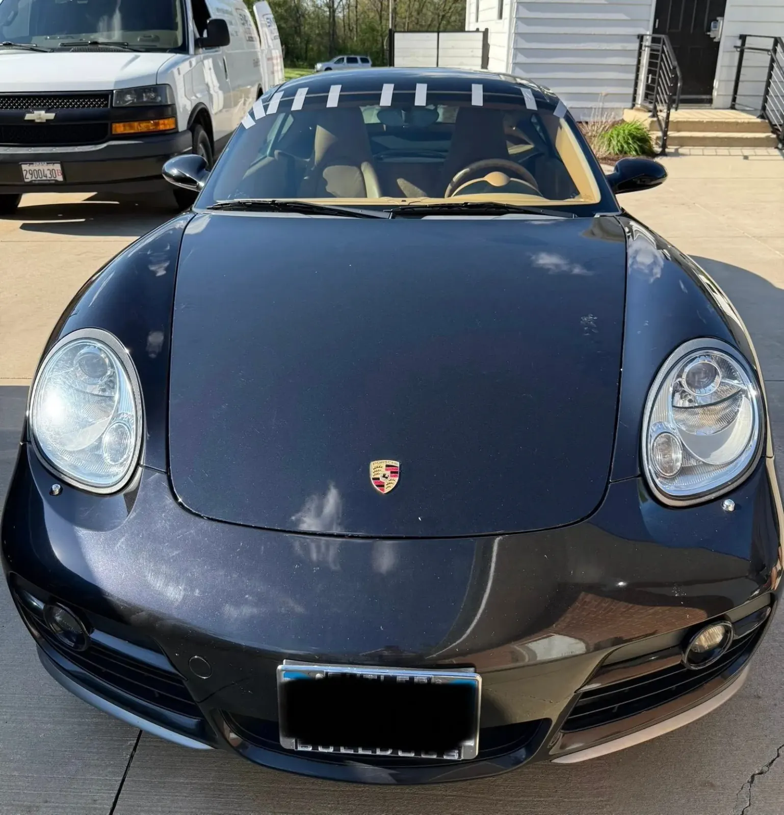 A black Porsche parked in a parking lot.