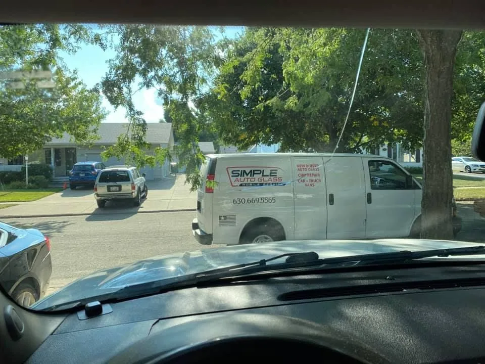 A white service van parked on the side of the road.